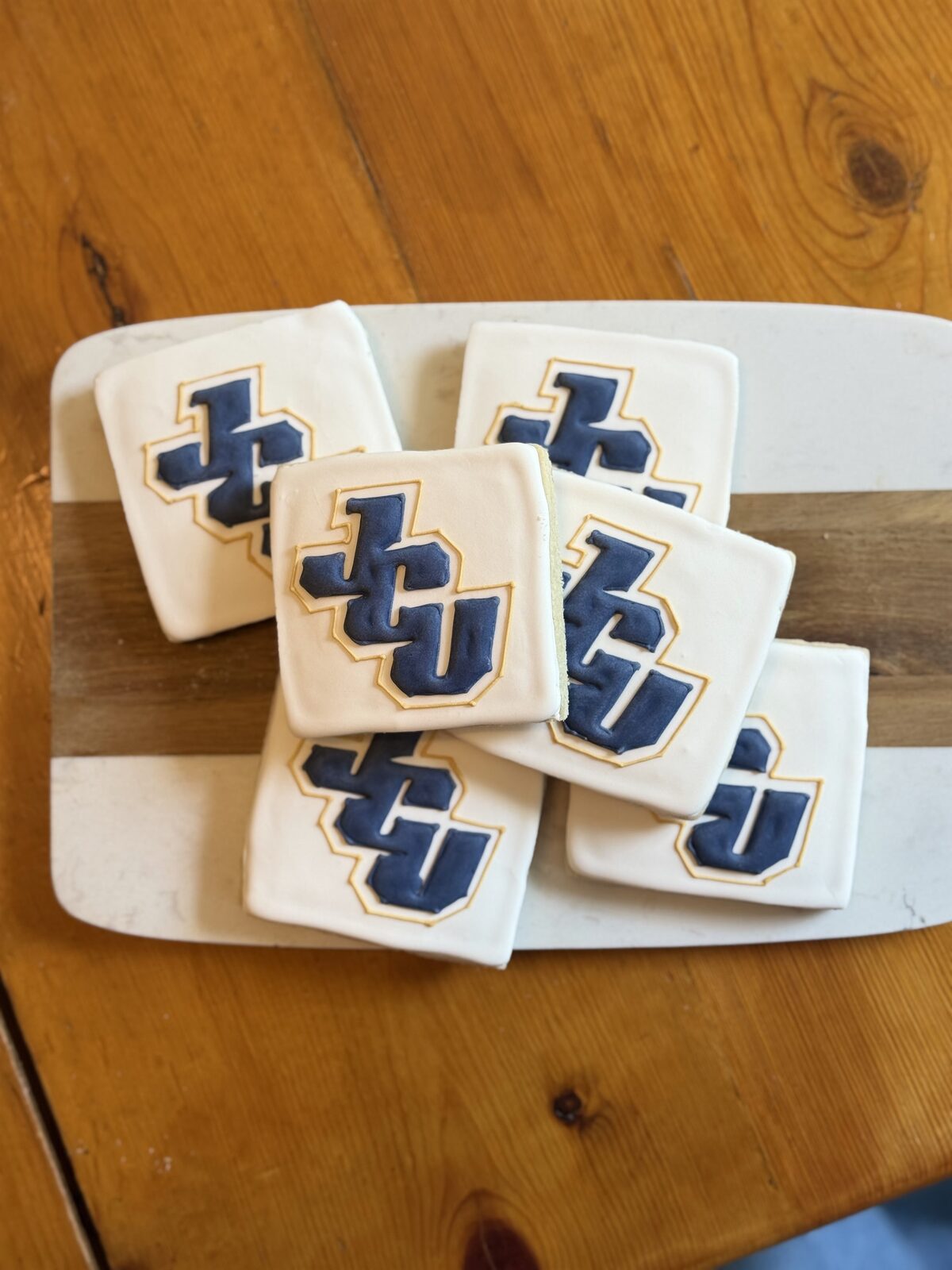 Square frosted logo cookies arranged on a serving plate.